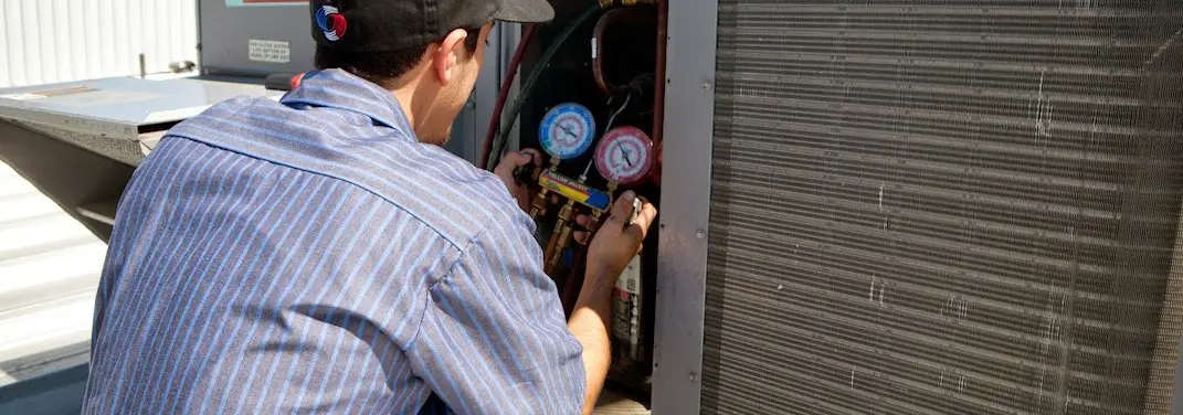HVAC technician servicing a condenser unit in Dahlonega