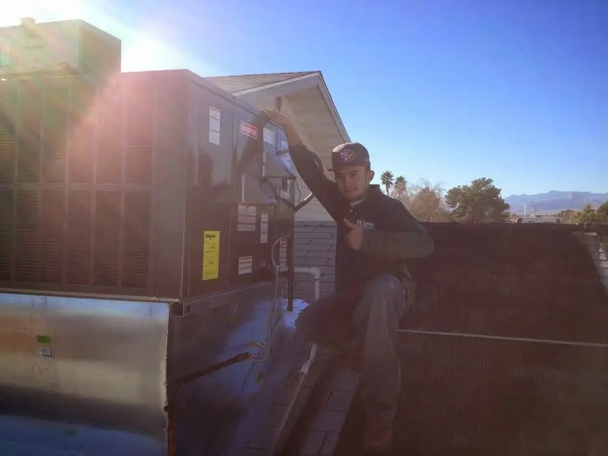 HVAC technician performing Boiler Repair on a rooftop unit in Dahlonega
